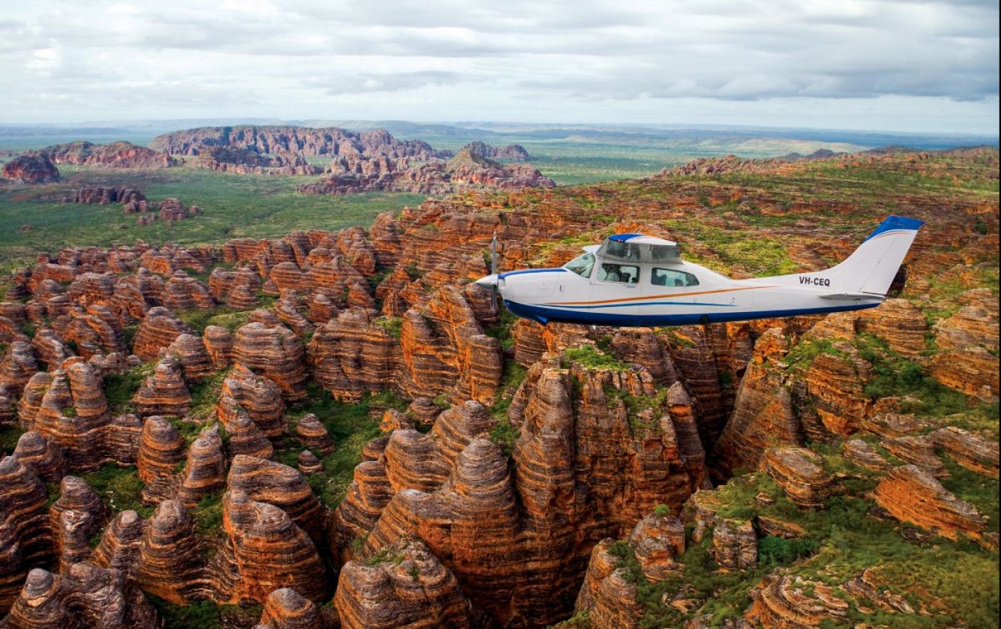 A plane flying across domes in the Bungle bungle range