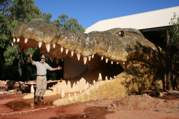 A man stands in the jaws of a fibreglass crocodile head