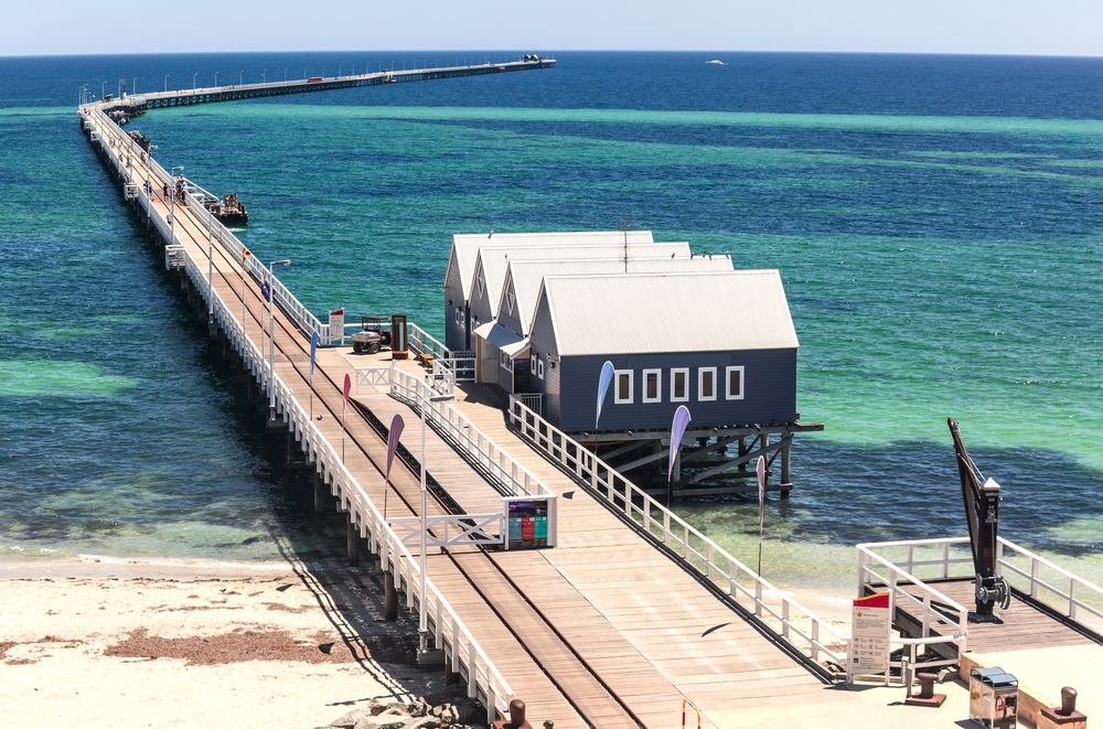 A drone image of a wooden piled timber jetty stretching out into the ocean