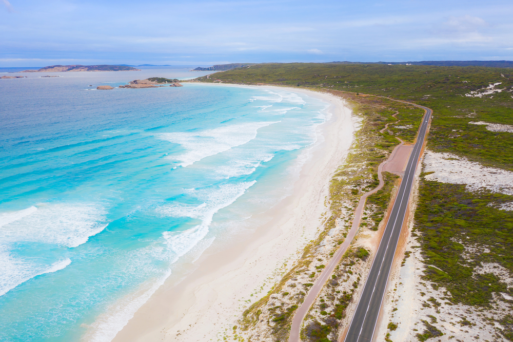 A drone image of the ocean with a road running alongside it