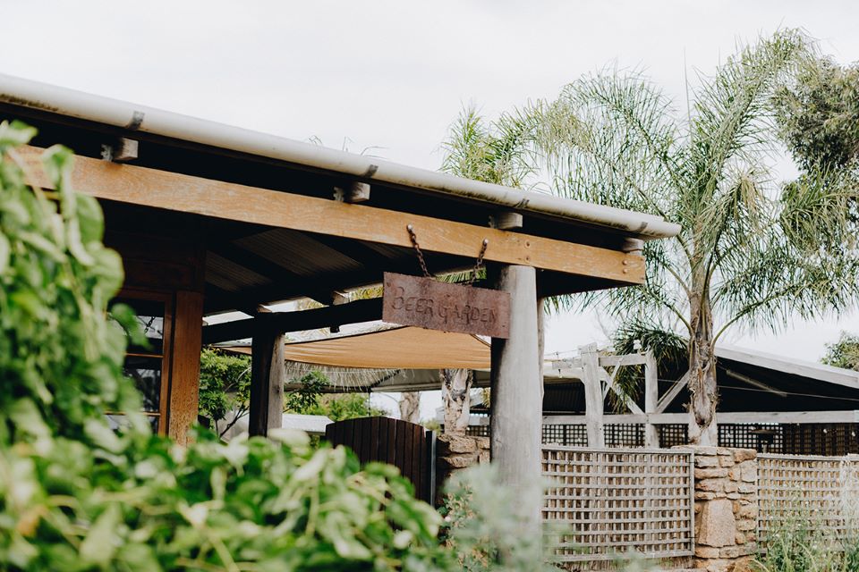 A sign of the Beer Garden hanging from a wooden roof