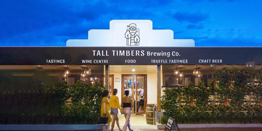 3 women walking into a brewery at night