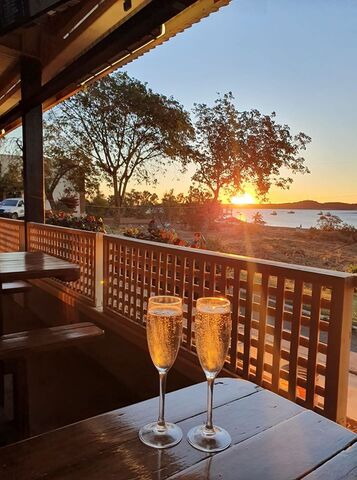 2 glasses of champagne on a table in front of the sunset