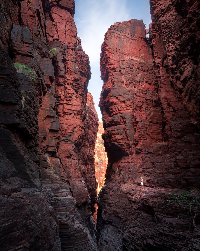 A woman stands on the edge of a cliff overlooking a gorge