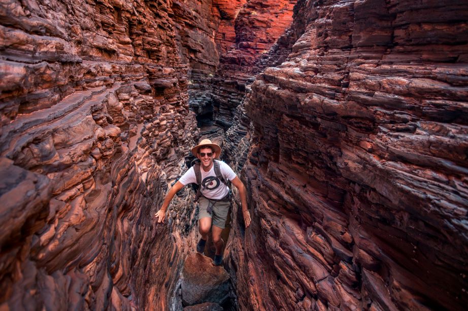 A man balances on a rock in a gorge