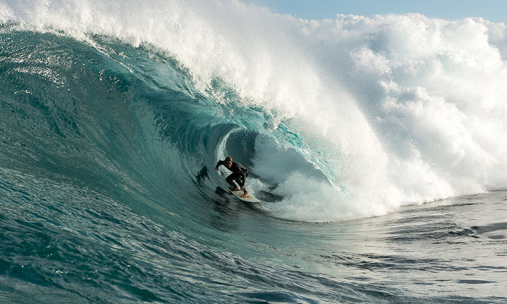 surfer riding barrel wave in margaret river