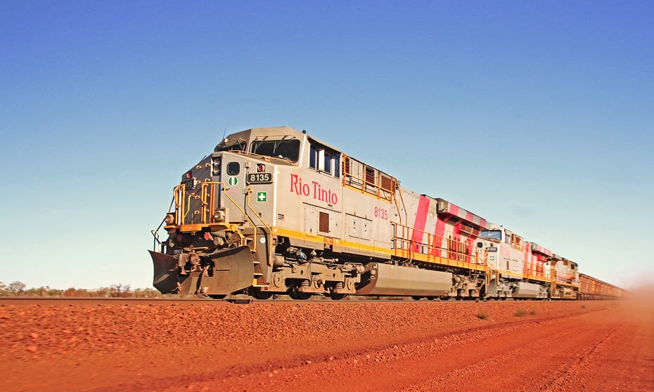 Iron ore mining operations train passing by Mount Nameless in Tom Price.