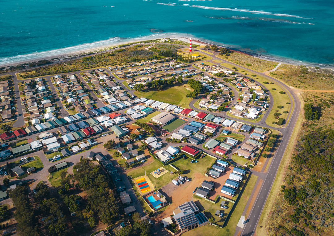 A drone image of a caravan park by the water.