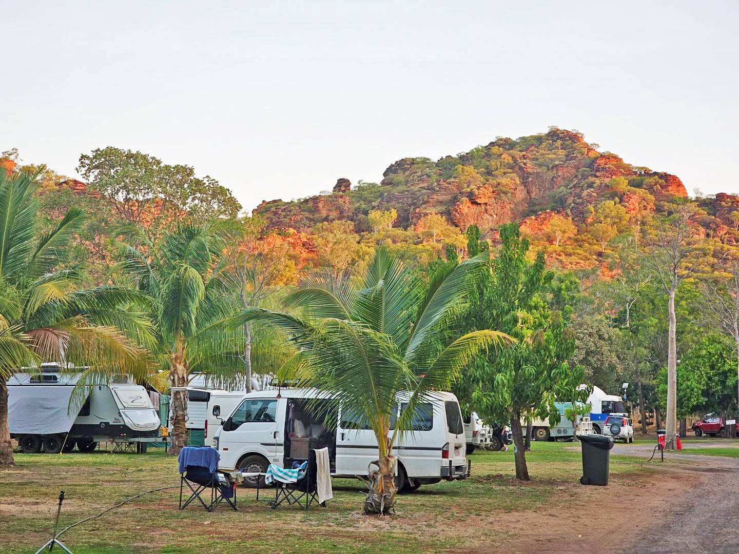 A van in a caravan park with the view of the mountains.