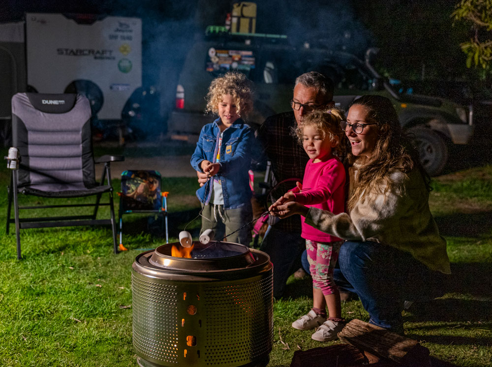 A family roast mashmallows on a fire pit at Busselton Lazy Days Caravan Park